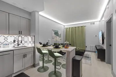 a kitchen with a table and some green chairs at 1 bedroom apartment near Disney and Universal in Orlando
