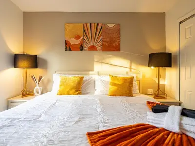 a bedroom with a large white bed with yellow pillows at The Enchanted luxe Townhome in Kissimmee