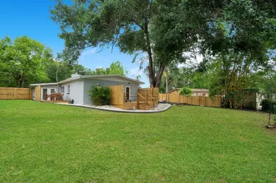 a small house in a yard with a fence at Lake view that is 10mins to Downtown and Parks for 2 Guests in Orlando