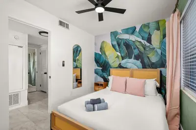 a bedroom with a bed with a painting on the wall at Game Filled Orlando Retreat with Patio and Grill in Orlando