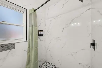 a white bathroom with a shower and a window at Game Filled Orlando Retreat with Patio and Grill in Orlando