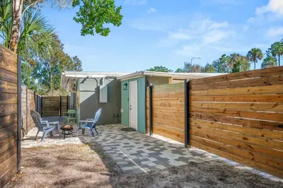a wooden fence with two chairs and a fire pit at Charming Private Studio Near Everything Orlando in Orlando