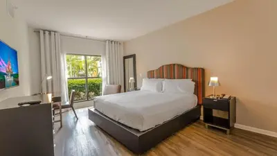 a bedroom with a bed and a large window at Apto 2Q no Meliá Celebration | Perto da Disney in Orlando