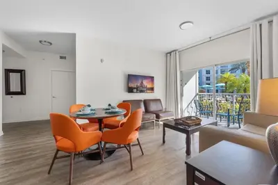 a living room with a table and chairs and a couch at Apto 2Q no Meliá Celebration | Perto da Disney in Orlando