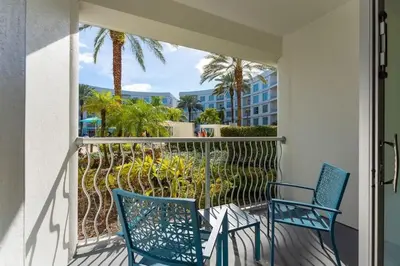 a balcony with two chairs and palm trees at Apto 2Q no Meliá Celebration | Perto da Disney in Orlando