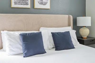 a bed with two blue pillows at Landing Stunning 2BD Yoga Studio Gym in Kissimmee