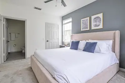 a bedroom with a large white bed with blue pillows at Landing Stunning 2BD Yoga Studio Gym in Kissimmee