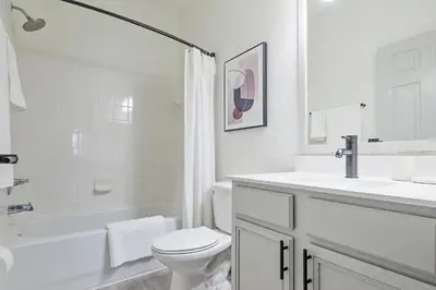 a white bathroom with a toilet and a sink at Landing Stunning 2BD Yoga Studio Gym in Kissimmee