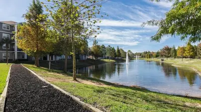 a view of a river with a building and trees at Landing Stunning 2BD Yoga Studio Gym in Kissimmee