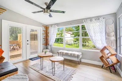 a living room with a ceiling fan and windows at Fireplace and Lake View Just 10 Minutes to Downtown Near Parks in Orlando