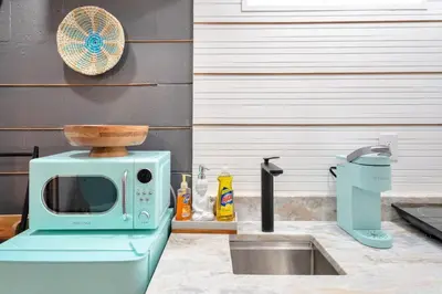 a microwave sitting on top of a kitchen sink at Peaceful Lake View Retreat Near Parks 10 Minutes to Downtown in Orlando