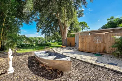 a wooden boat sitting on the ground in a yard at Peaceful Lake View Retreat Near Parks 10 Minutes to Downtown in Orlando