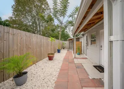 a house with a fence and a walkway with potted plants at Studio in the heart of Orlando in Orlando