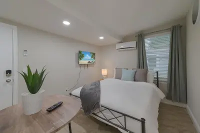 a bedroom with a white bed and a table at Comfy studio in Central Orlando in Orlando