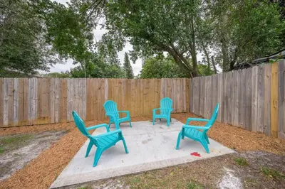 four blue chairs sitting on a concrete slab in front of a fence at Comfy studio in Central Orlando in Orlando
