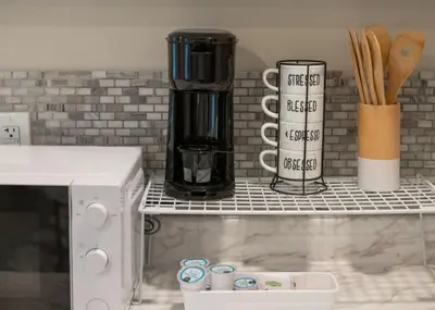 a kitchen counter with a coffee maker on a shelf at Private Studio near parks and Downtown in Orlando