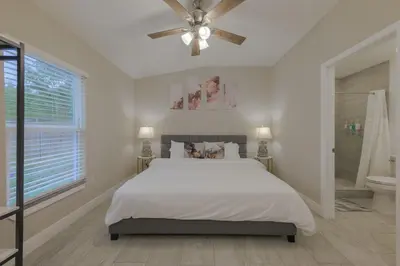 a white bedroom with a bed and a ceiling fan at Private Studio near parks and Downtown in Orlando
