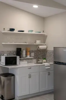 a white kitchen with a sink and a refrigerator at Private Studio near parks and Downtown in Orlando