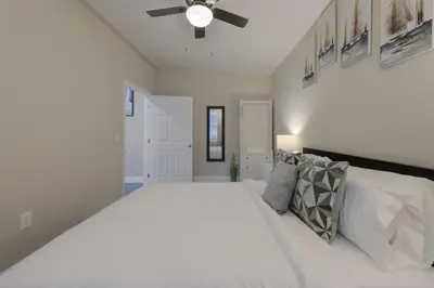 a bedroom with a large white bed with a ceiling fan at Comfortable 1 bedroom home in Orlando