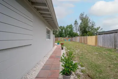 a backyard with a white wall and a fence at Comfortable 1 bedroom home in Orlando