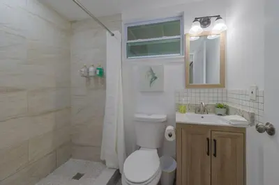 a bathroom with a toilet and a sink and a mirror at Comfortable 1 bedroom home in Orlando