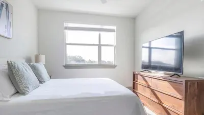 a bedroom with a bed and a flat screen tv at Landing Chic 1BD Gym Pool in Sanford