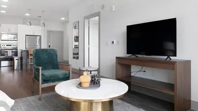 a living room with a flat screen tv and a table at Landing Chic 1BD Gym Pool in Sanford