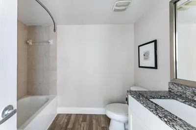 a bathroom with a tub and a toilet and a sink at Landing Chic 1BD Gym in Orlando