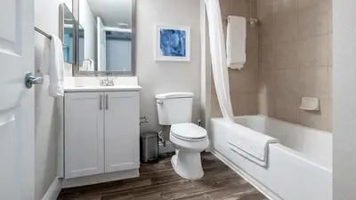 a bathroom with a toilet and a sink and a tub at Landing Chic 1BD Gym in Orlando