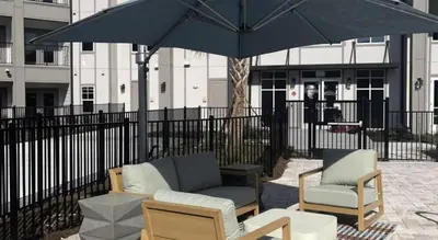 a patio with two chairs and an umbrella at Landing Beautiful 2BD in Kissimmee in Kissimmee