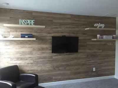 a living room with a wooden wall with a television at 4715 SH - Storey Lake Hideaway 6BR Mansion Private Pool in Kissimmee