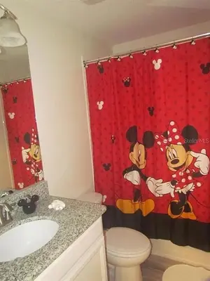 a bathroom with a mickey mouse shower curtain at 4715 SH - Storey Lake Hideaway 6BR Mansion Private Pool in Kissimmee