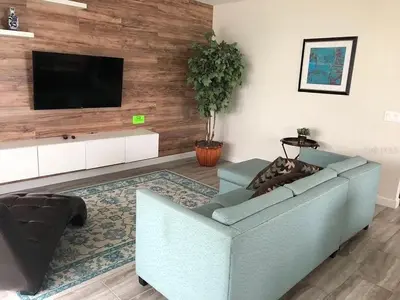 a living room with a couch and a flat screen tv at 4715 SH - Storey Lake Hideaway 6BR Mansion Private Pool in Kissimmee