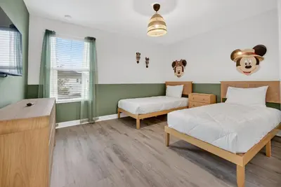two beds in a room with green and white walls at 4715 SH - Storey Lake Hideaway 6BR Mansion Private Pool in Kissimmee