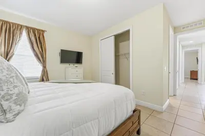 a bedroom with a large white bed and a television at Encore Resort luxury house 8 bedrooms, pool and spa in Orlando