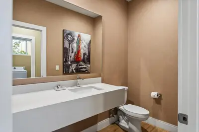 a bathroom with a sink and a toilet and a mirror at Bright and Modern Townhome at Magic Village – Superb Disney Location in Orlando