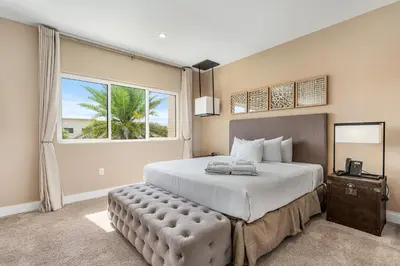 a bedroom with a large bed with a large window at Bright and Modern Townhome at Magic Village – Superb Disney Location in Orlando