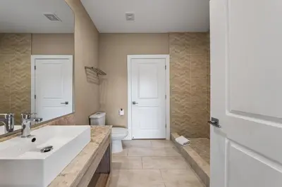 a bathroom with a white sink and a toilet at Bright and Modern Townhome at Magic Village – Superb Disney Location in Orlando