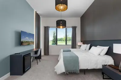 a bedroom with a bed and a desk and a television at Brand New Modern State of the Art Home! Sleeps 31 in Kissimmee