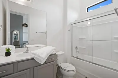 a white bathroom with a shower and a toilet at Brand New Modern State of the Art Home! Sleeps 31 in Kissimmee