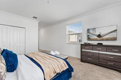 a bedroom with a bed and a tv on the wall at 5BR/5BA Home & Storey Lake Water Park Amenities in Kissimmee