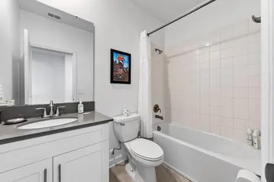 a white bathroom with a toilet and a sink at 5BR/5BA Home & Storey Lake Water Park Amenities in Kissimmee