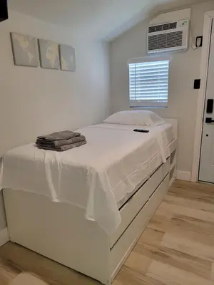 a white bed in a room with a window at A cozy stay with everything you need! in Kissimmee