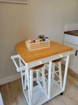 a small white table in a kitchen with two stools at A cozy stay with everything you need! in Kissimmee