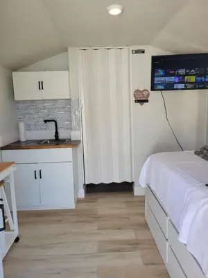 a bedroom with a bed and a kitchen with a sink at A cozy stay with everything you need! in Kissimmee