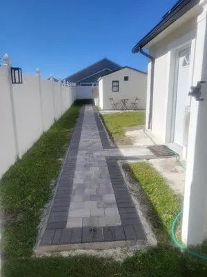 a walkway next to a white fence at A cozy stay with everything you need! in Kissimmee