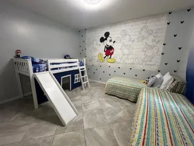 a bedroom with a mickey mouse mural on the wall at Magical Apartment DisneyFree ShuttleFree parking in Kissimmee