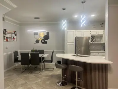 a kitchen with a table and chairs and a refrigerator at Magical Apartment DisneyFree ShuttleFree parking in Kissimmee