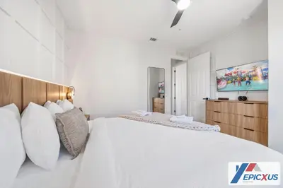 a white bedroom with a large bed with white pillows at The Epic 3 Lake View Vista Cay Resort Orlando Florida in Orlando