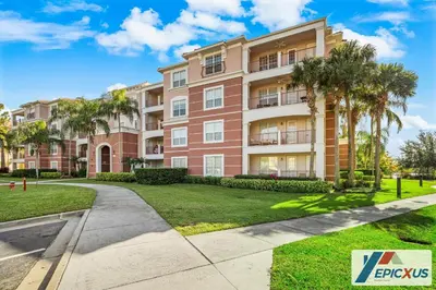 an apartment building with palm trees and a sidewalk at The Epic 3 Lake View Vista Cay Resort Orlando Florida in Orlando